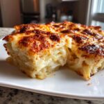 A close-up of a rich, creamy slice of scalloped potatoes with a deeply browned, cheesy crust.