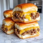 A stack of four delicious cheeseburger sliders featuring ground beef filling and melted yellow cheese on soft buns.