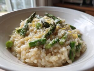 Close-up of creamy Asparagus Risotto topped with bright green asparagus tips, Parmesan cheese, and lemon zest.