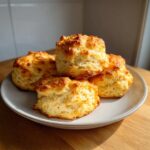 A stack of four golden brown Drop Buttermilk Biscuits piled on a light gray plate.