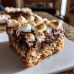 A single, thick square of S'mores bars featuring a graham cracker crust, melted chocolate, and toasted mini marshmallows on top.