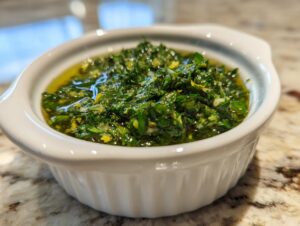 Close-up of vibrant green Mint gremolata mixed with olive oil in a small white serving dish.